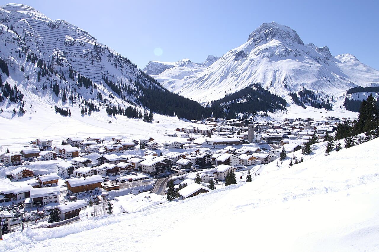 Lech am Arlberg in winter, church tower in the valley under the Omeshorn